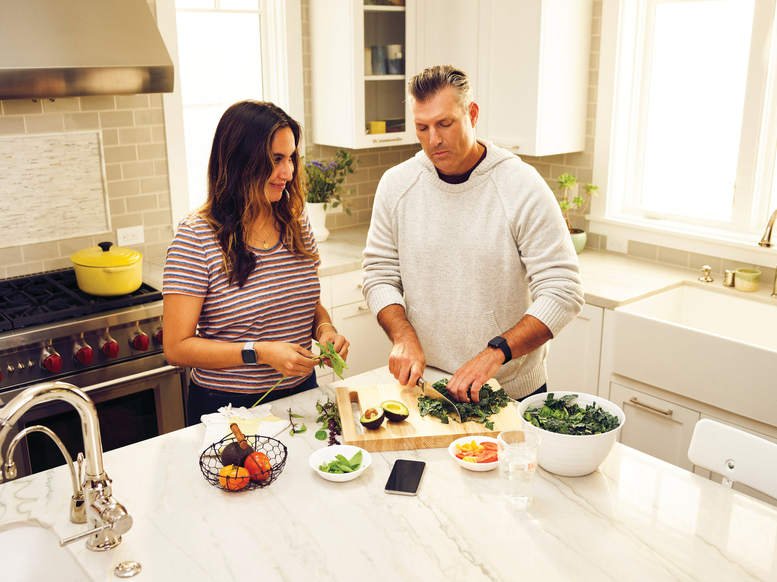Man and woman in kitchen chopping vegetables