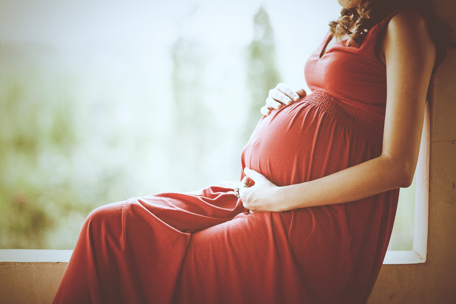 Pregnant woman sat holding bump