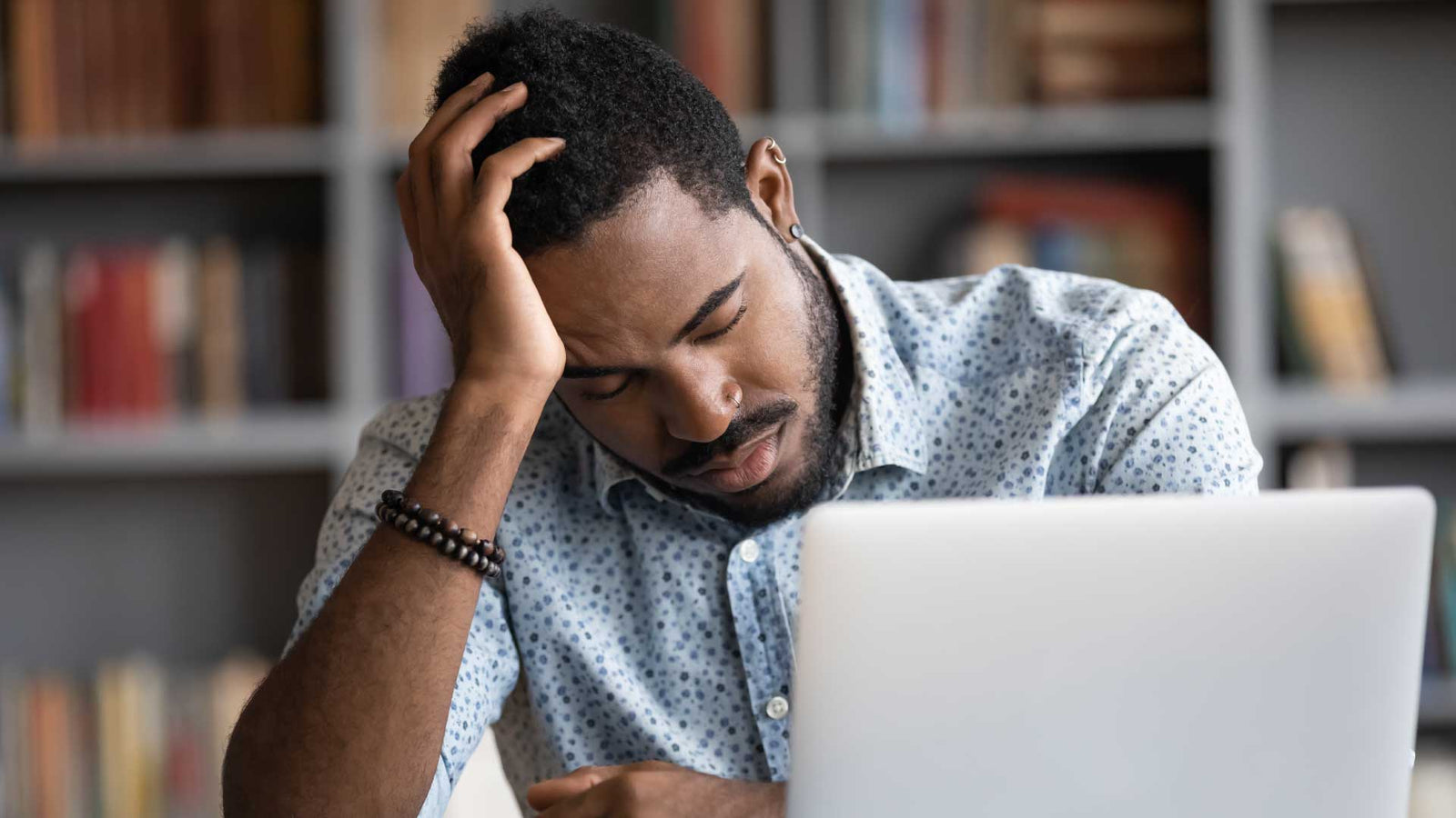 Man with migraine holding his head in pain