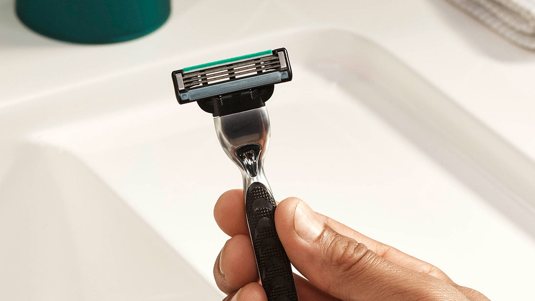 a hand holding a Gillette Mach 3 razor