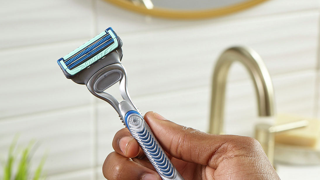 Hand holding a Gillette SkinGuard Sensitive razor