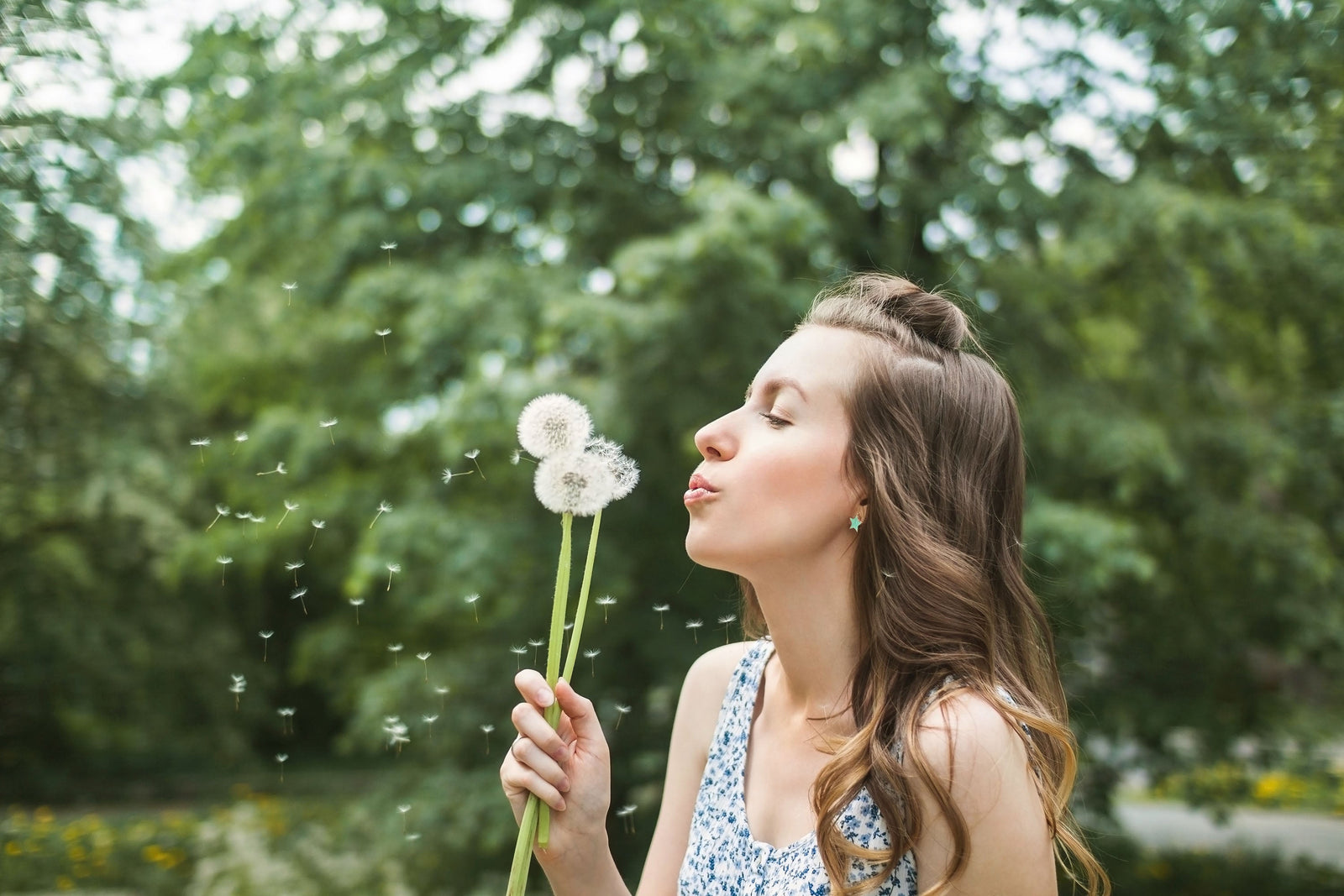 Woman blowing dandelion
