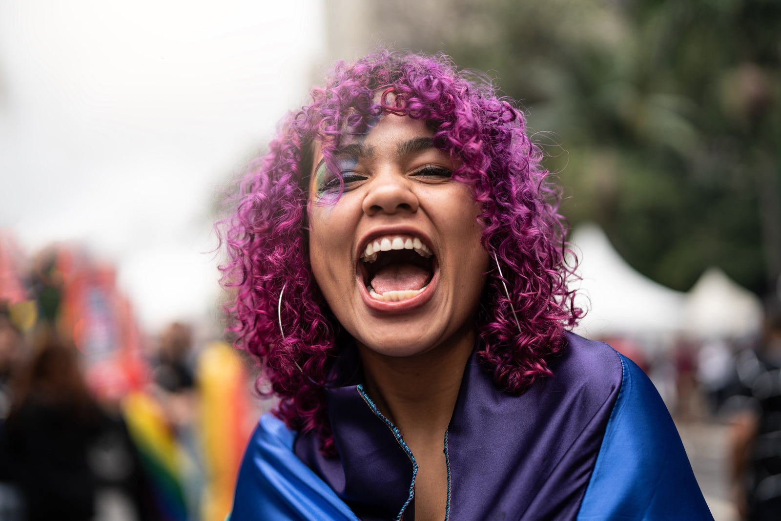 woman with purple curly hair smiling with mouth open