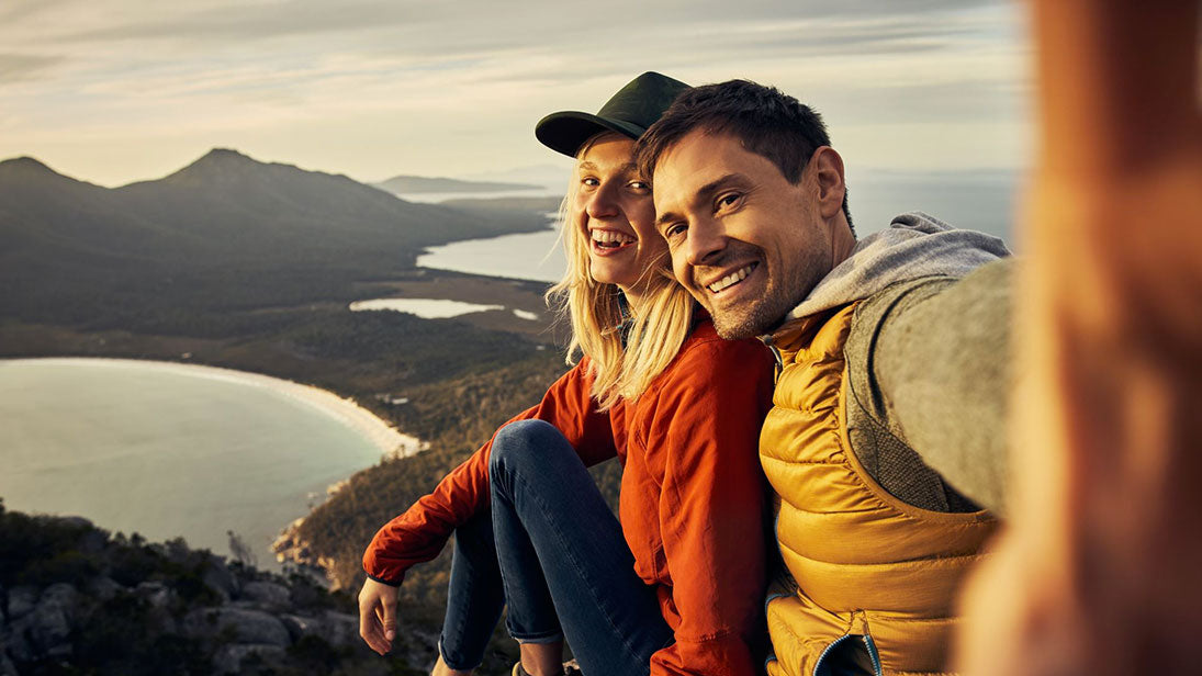 man and woman taking a selfie photo on a mountain